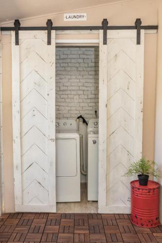 a sliding barn door in a laundry room with a washer and dryer at Coastal Farmhouse with mini Golf, Private Beach &Spa in Naples