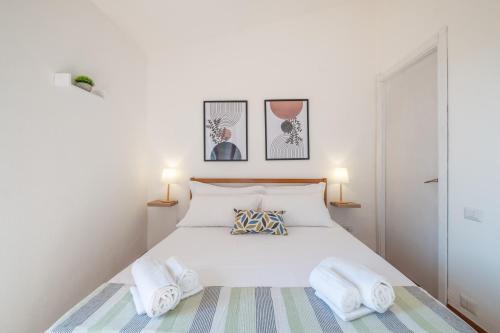 una camera con un letto bianco con due cuscini di Suite Capitana Harbor-Self Checkin-Terrace-Netflix a Santa Luria