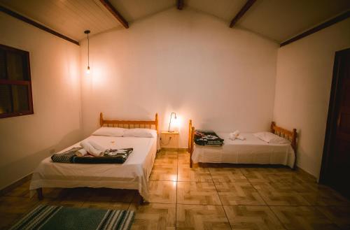 a room with two beds and a lamp in it at Lago 7 Cores in Tapiraí