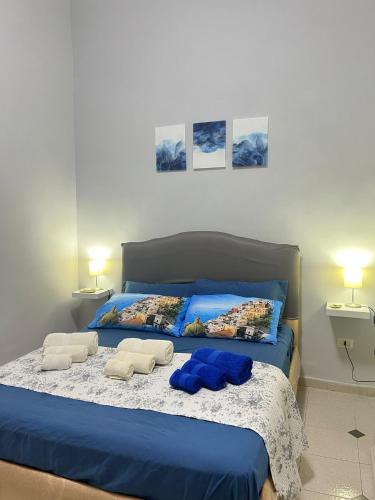 una camera da letto con un letto blu con due asciugamani sopra di ZìMarì Apartment a Napoli