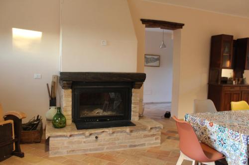a living room with a fireplace and a table at La Casa nell'Orto in Fermo