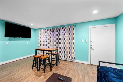a living room with a table and chairs and a tv at 1-Bedroom Haven in Murworth, Close to Medical Center in Houston