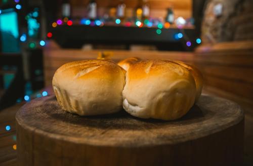 two loaves of bread sitting on a wooden plate at Lago 7 Cores in Tapiraí