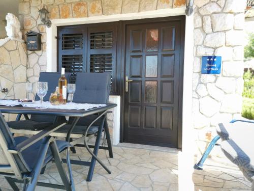 einen Tisch und Stühle auf einer Terrasse mit Tür in der Unterkunft Apartman Rahela in Selce