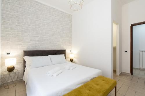 a bedroom with a white bed and a brick wall at Ciampino-Roma - Modern Apartment-Airport & Station in Ciampino