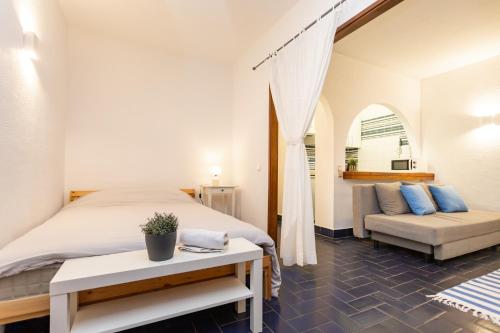 een slaapkamer met een groot bed en een bank bij Blue Horizon House in Costa da Caparica
