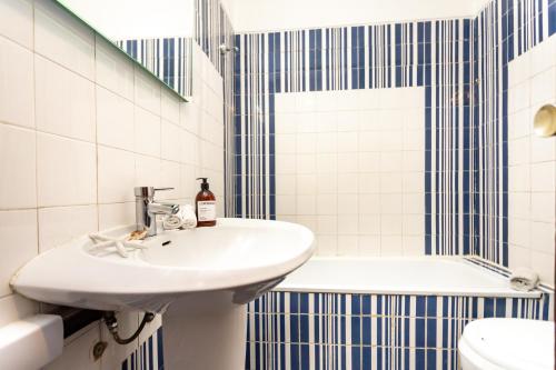 een badkamer met een wastafel, een toilet en een bad bij Blue Horizon House in Costa da Caparica