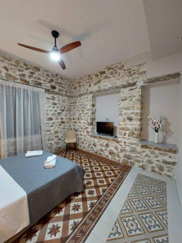 a bedroom with a bed and a stone wall at Stone-built Villa Nesseris 80 m2 in Preveza