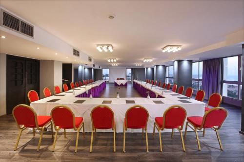 a large conference room with a long table and red chairs at Anezi Tower Hotel in Agadir