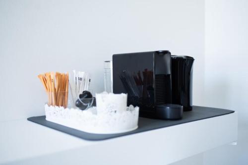 a black shelf with a coffee maker on it at Luxe Apartment near Milano, Rho Fiera e MXP in Legnano
