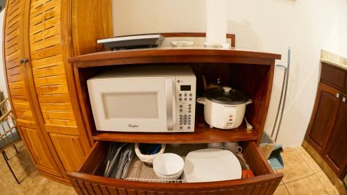 a kitchen with a microwave and a mixer on a shelf at Villas Welcome to Heaven in Carrillo