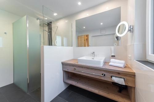 a bathroom with a sink and a mirror at Hotel Bergkristall in Silbertal