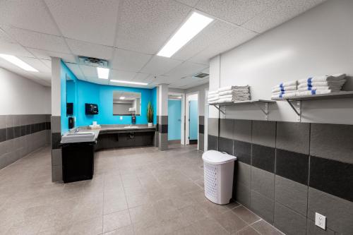 a bathroom with two sinks and a blue wall at The Kanata by BCMInns - Hinton in Hinton
