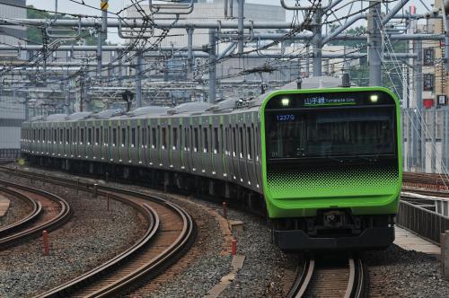 a green train is traveling down the tracks at Henn na Hotel Tokyo Hamamatsucho in Tokyo