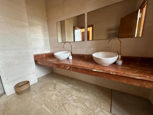 Un baño con dos lavabos y un espejo. en Dar Kbira, en Dar Bouazza