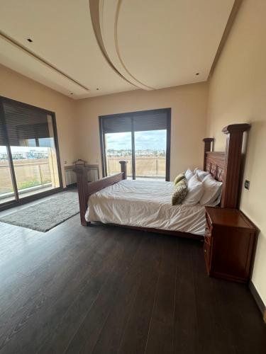 Un dormitorio con una cama y una ventana grande. en Dar Kbira, en Dar Bouazza