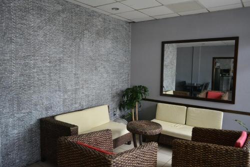 a waiting room with a couch and chairs and a mirror at Travel Inn Hotel Simpson Bay in Simpson Bay