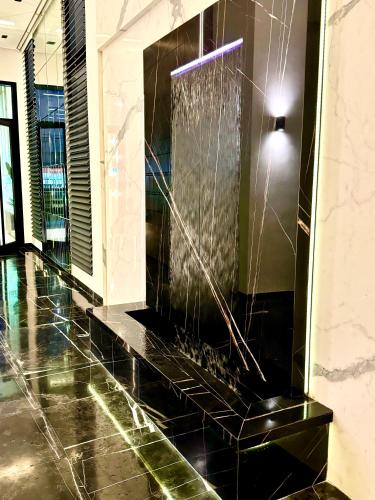 a lobby with a water fountain in a building at Appart avec piscine commune à Hammamet 5min de la plage in Hammamet Nord