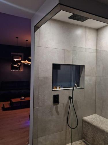 La salle de bains est pourvue d'une douche et d'une télévision murale. dans l'établissement Suite avec jacuzzi & terrasse vue sur l'Orb, à Béziers