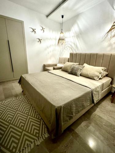 a bedroom with a bed with birds on the wall at Appart avec piscine commune à Hammamet 5min de la plage in Hammamet Nord