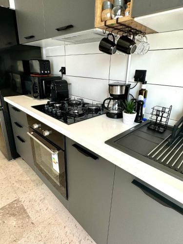 a kitchen with a stove and a counter top at Appart avec piscine commune à Hammamet 5min de la plage in Hammamet Nord