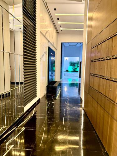 a hallway of a building with black flooring and a hallway at Appart avec piscine commune à Hammamet 5min de la plage in Hammamet Nord