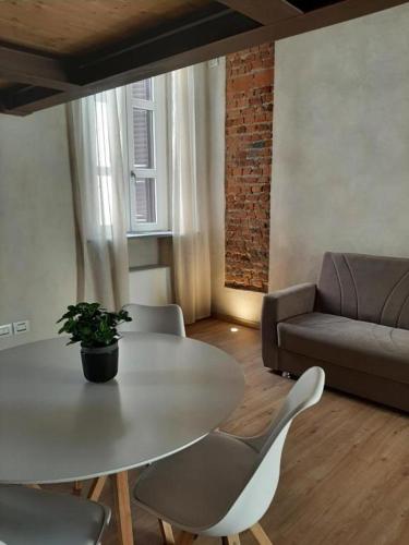 a living room with a table and chairs and a couch at Il Garibaldi in Savigliano