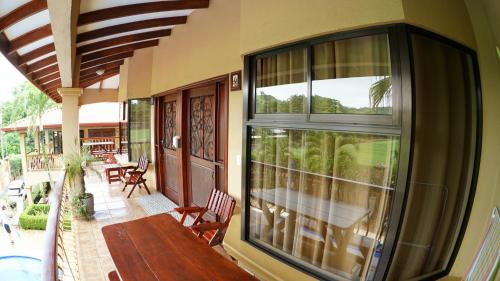 a balcony with a wooden bench on a house at Villas Welcome to Heaven in Carrillo