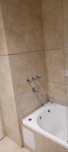 a bathroom with a shower with a sink and a tub at Rincon del Sol in Pinamar