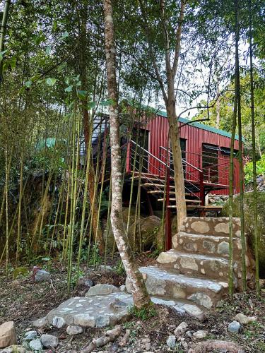 a red train car in the middle of a forest at Hotel de Montaña El Pelicano in San Isidro