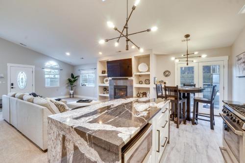 a kitchen and living room with a large marble counter top at Near Red Rocks Golden Getaway with Deck! in Golden