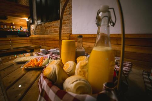 a table with a bottle of orange juice and bread at Lago 7 Cores in Tapiraí