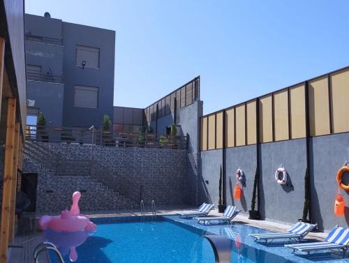 una piscina con un cerdo rosa en el agua en Villa limas, en Al Baḩḩāth