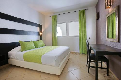 1 dormitorio con cama, mesa y escritorio en Anezi Apartments, en Agadir