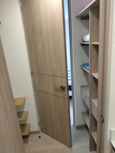 a closet with a wooden door in a room at Apartamento Sabaneta Antioquía in Sabaneta