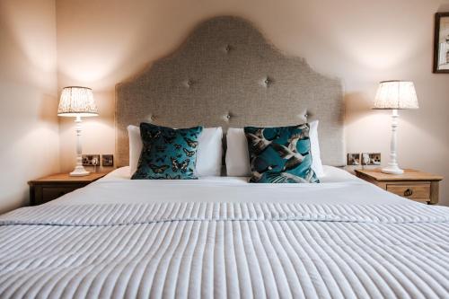 アルサガーにあるManor House Hotel & Spa, Alsagerの大きな白いベッドと2つのランプのある寝室