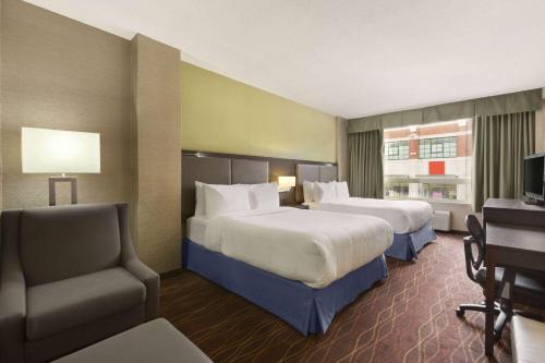 Giường trong phòng chung tại Days Inn by Wyndham Ottawa