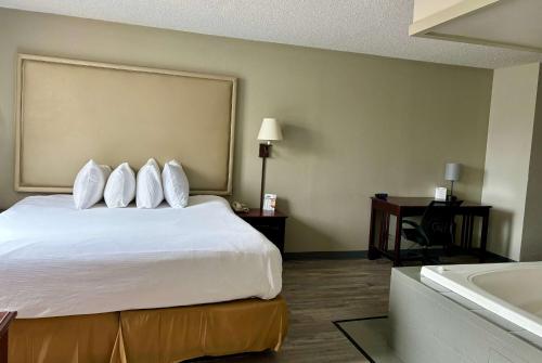 a hotel room with a bed and a bath tub at Baymont by Wyndham Keokuk in Keokuk