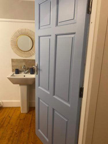 a bathroom door with a sink and a mirror at Stay in Annascaul Village at Aido's in Annascaul