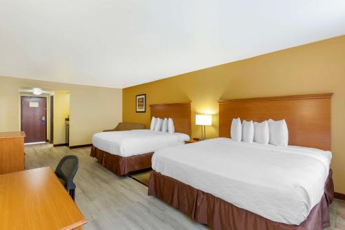a hotel room with two beds and a table at Best Western Kiva Inn in Fort Collins