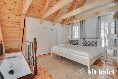 a bedroom with a bed in a room with wooden ceilings at Älpha-M - magnifique vue sur le fleuve in Baie-Saint-Paul