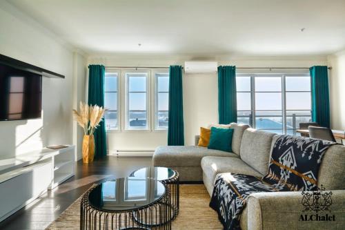 a living room with a couch and a table at Le Chic Condo - chute Montmorency in Boischâtel