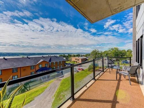 a balcony with a view of a house at Le Chic Condo - chute Montmorency in Boischâtel