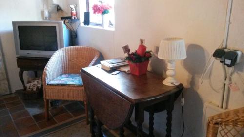 Habitación con escritorio con lámpara y TV. en B&B aan de Limes in Maurik, en Maurik