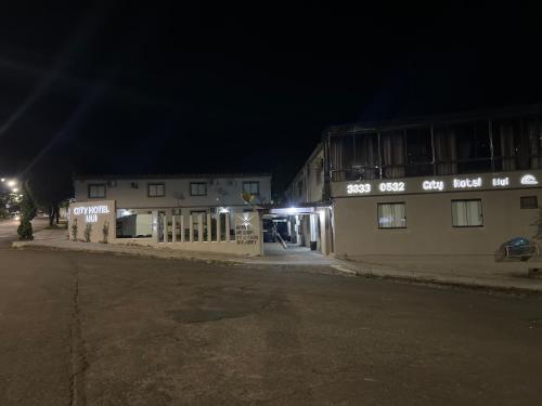 a couple of buildings on a street at night at Ciity Hotel ijui in Ijuí