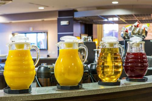three glass pitchers of beer sitting on a counter at Cambria Hotel Raleigh-Durham Airport in Morrisville