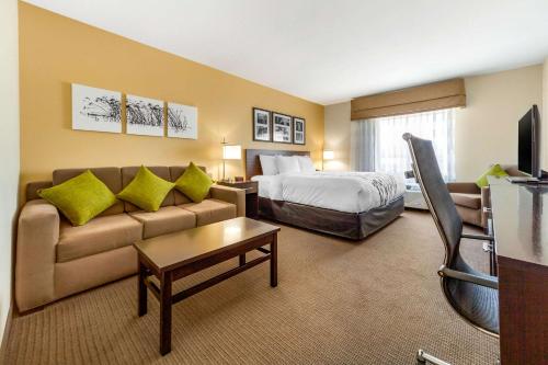 a hotel room with a bed and a couch at Sleep Inn & Suites Lincoln University Area in Lincoln