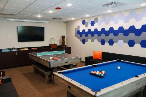 a room with a pool table and a flat screen tv at Sleep Inn & Suites Lincoln University Area in Lincoln