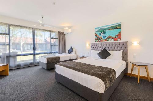 a hotel room with two beds and a large window at Quality Hotel Lincoln Green in Auckland