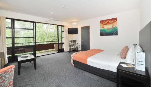 a hotel room with a bed and a tv at Quality Hotel Lincoln Green in Auckland